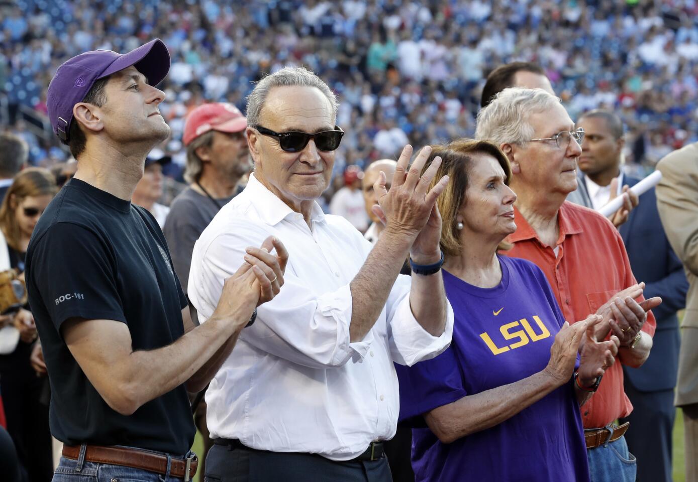 House Speaker Paul D. Ryan (R-Wis.), Senate Minority Leader Charles E. Schumer (D-N.Y.), House Minority Leader Nancy Pelosi (D-San Francisco) and Senate Majority Leader Mitch McConnell (R-Ky.), from left, applaud a message on the video board from President Trump before the game begins.