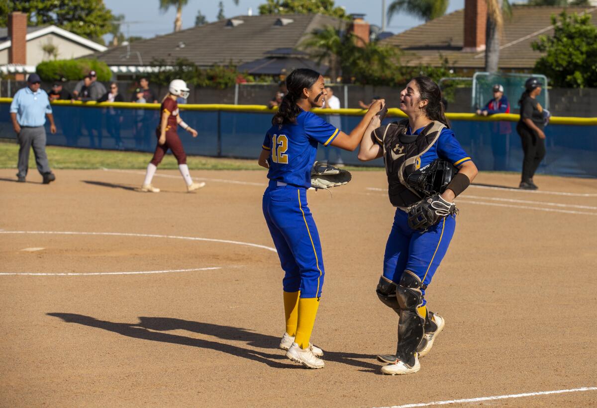 Fountain Valley's Courtney Kols, left, gets a high-five from catcher Brooke Bonny after pitching a complete game.