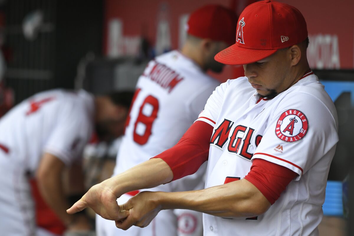 Angels pitcher Hansel Robles stretches his hand before pitching in the ninth inning against the Tampa Bay Rays on Sunday.