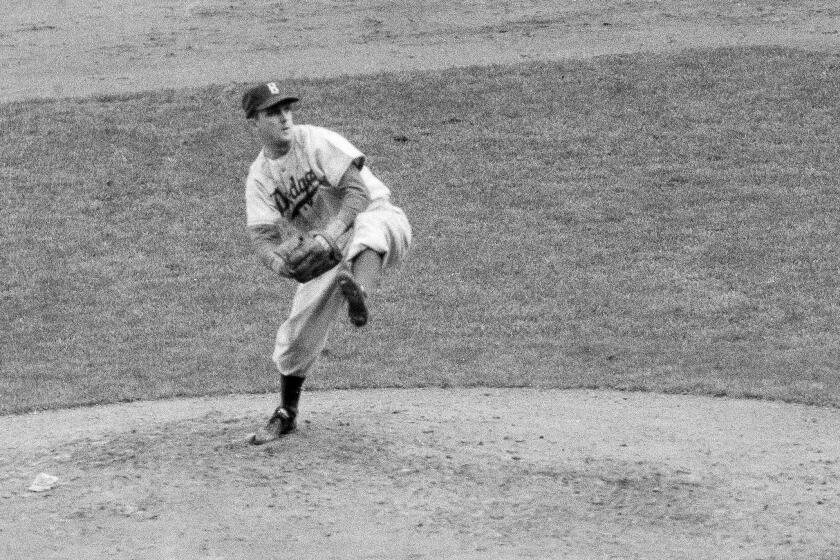 FILE - In this October 1952 file photo, Brooklyn Dodgers' Carl Erskine pitches against the New York Yankees in Game 5 of the baseball World Series in New York. Up by 13 1/2 games in mid-August in 1951, Jackie Robinson and the Dodgers seemed destined. That was until rookie Willie Mays and the New York Giants came flying back, fueled by an incredible, late run in home games at the Polo Grounds, and forced a best-of-three playoff for the National League pennant. Erskine was warming up in the Brooklyn bullpen in Game 3 when Bobby Thomson connected for the famed "Shot Heard 'Round the World," a three-run homer in the bottom of the ninth off Ralph Branca that rallied the Giants to a 5-4 win. A half-century later, a giant secret was revealed: The Giants had rigged a spyglass-and-buzzer system in late July to steal catchers' signals and tip off their hitters. (AP Photo, File)