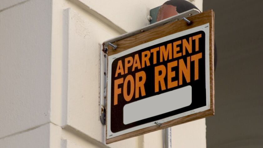 A for rent sign on display on the side of an apartment building.