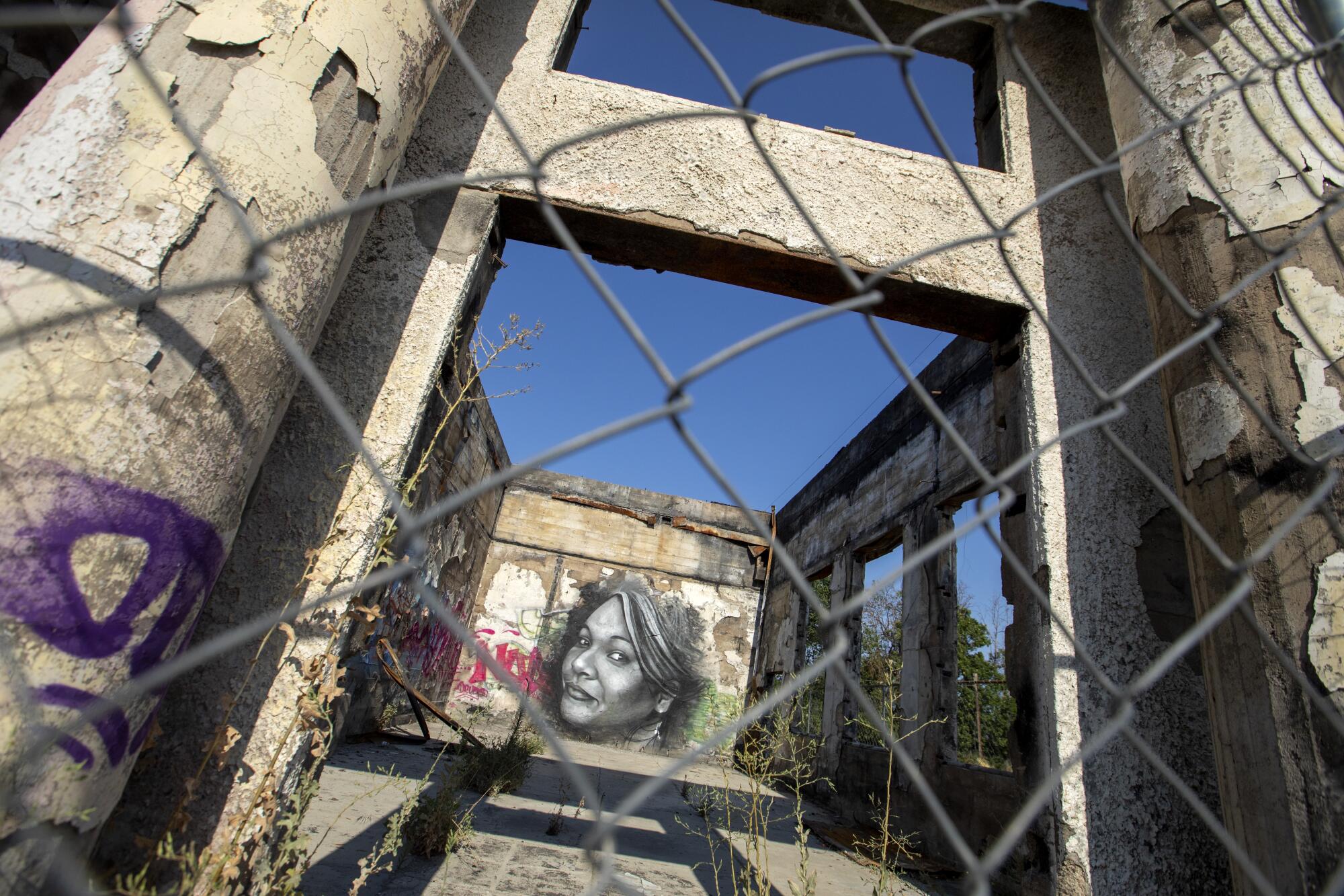 A mural is painted on the inside wall of a burned out building