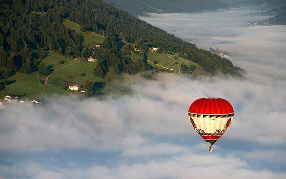 A hot-air balloon flies over the morning mist near Immenstadt in Allgaeu, southern Germany. The adventurous alternative to hiking is called balloon-trekking, in which passengers, equipped with a compass and a map, have to find their way back to the departure site by foot after a trip with the balloon.
