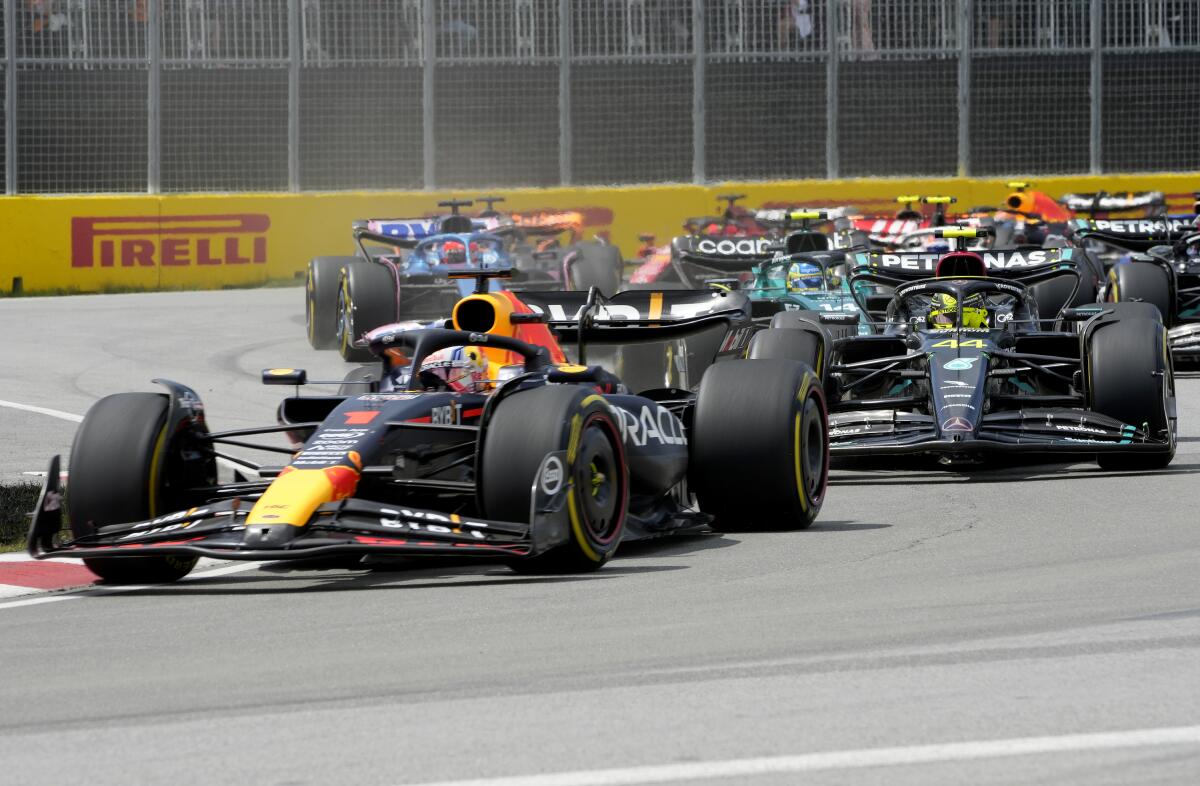 Black F1 cars race on a track 