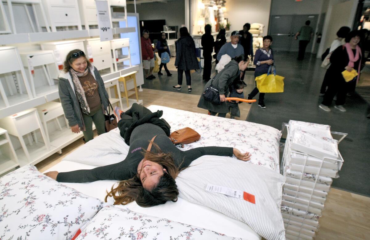 Julissa Camacho, 30 of San Gabriel, tries out the beds during the grand opening of the new IKEA.