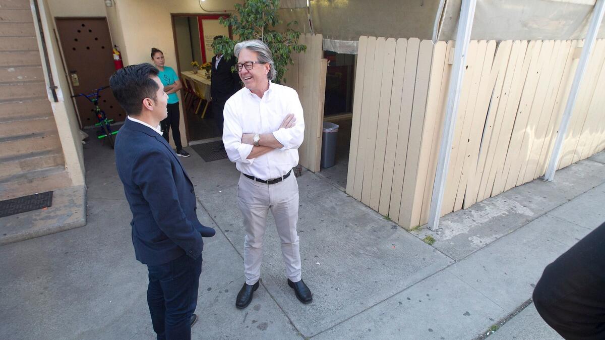 THINK Together board member Paolo Leon and CEO Randy Barth, from left, chat in front of the Shalimar Learning Center in Costa Mesa.