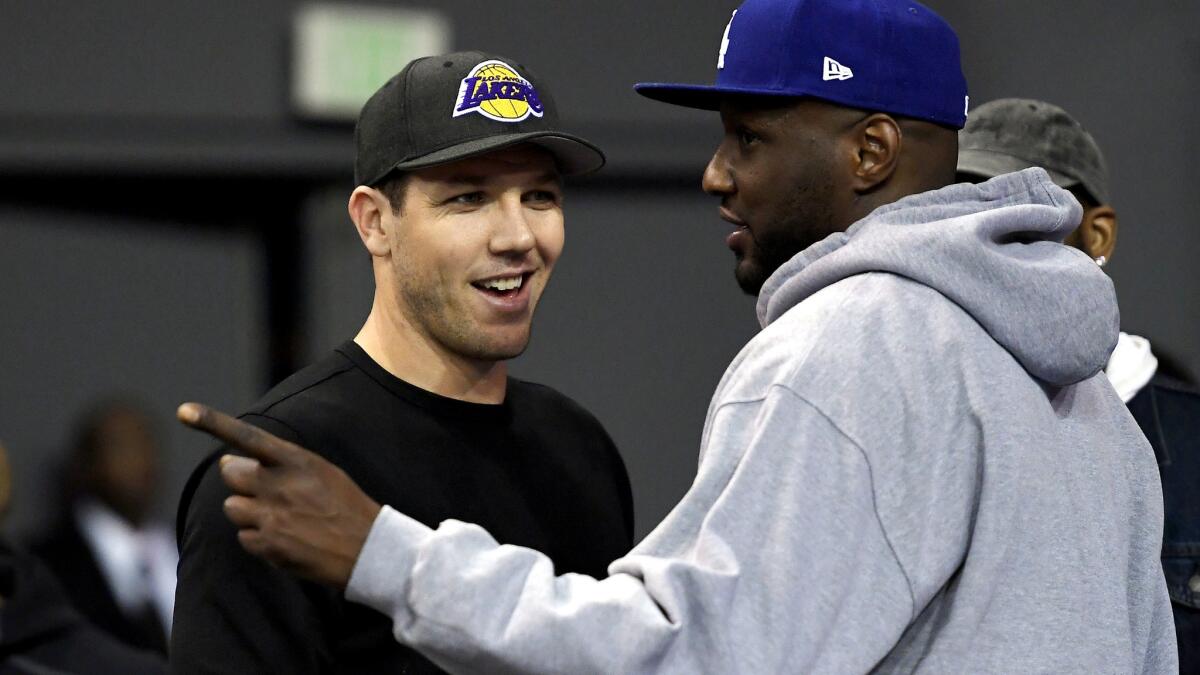 Lakers Coach Luke Walton chats with former NBA teammate Lamar Odom during the first half of UCLA's game against Washington on Tuesday at Pauley Pavilion.