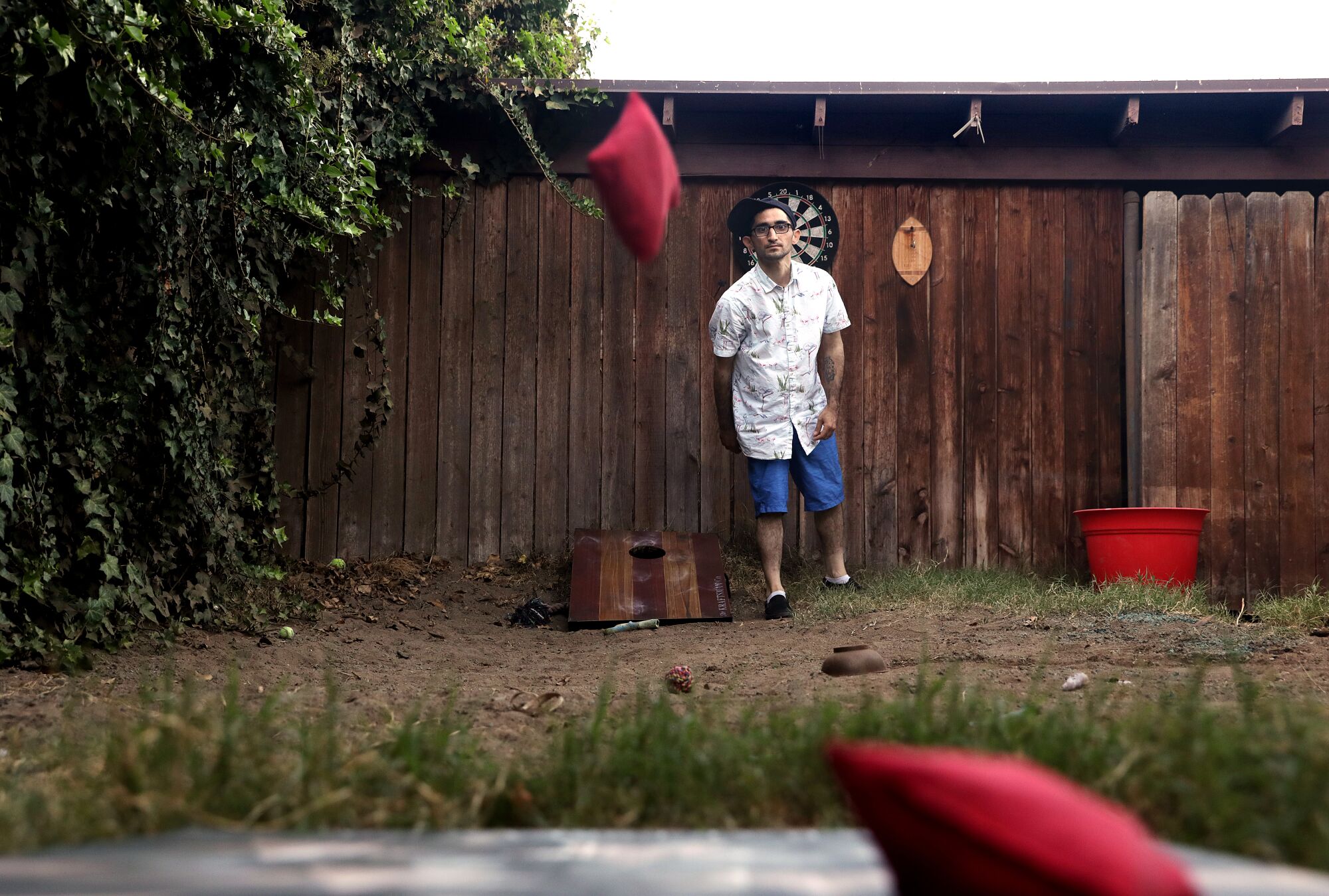 A man throws a sack in a corn hole game