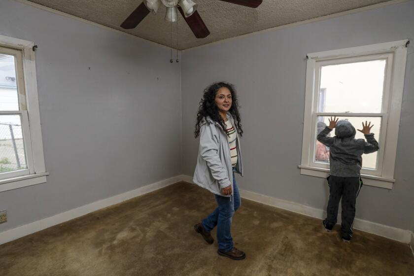 LOS ANGELES, CA - MARCH 14, 2020 - Ruby Gordillo, 33, and her 8-year-old son Jacob Gordillo check out of a vacant house she has occupied on Saturday morning. Impacted by the housing crisis, and feeling even more urgency in the wake of the Coronavirus pandemic, a group of families who need safe and healthy housing went to "reclaimed" 6 vacant houses owned by the state in the El Sereno neighborhood of Los Angeles. The vacant properties are currently owned by Caltrans, purchased decades ago as part of the now aborted 710 freeway expansion. Over 200 now sit vacant while thousands live on the streets of Los Angeles County. (Irfan Khan / Los Angeles Times)
