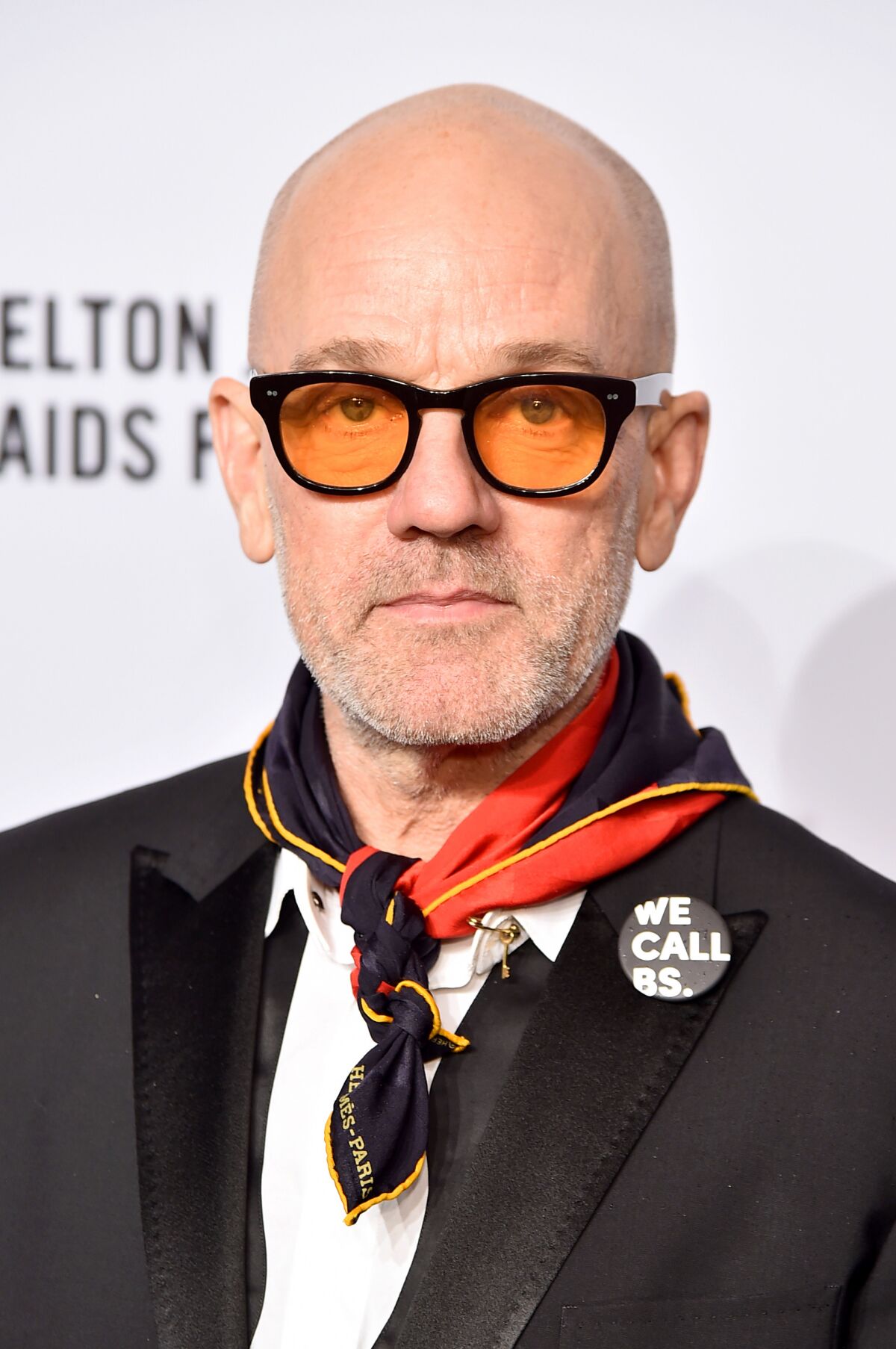 A man wearing tinted eyeglasses and a kerchief.
