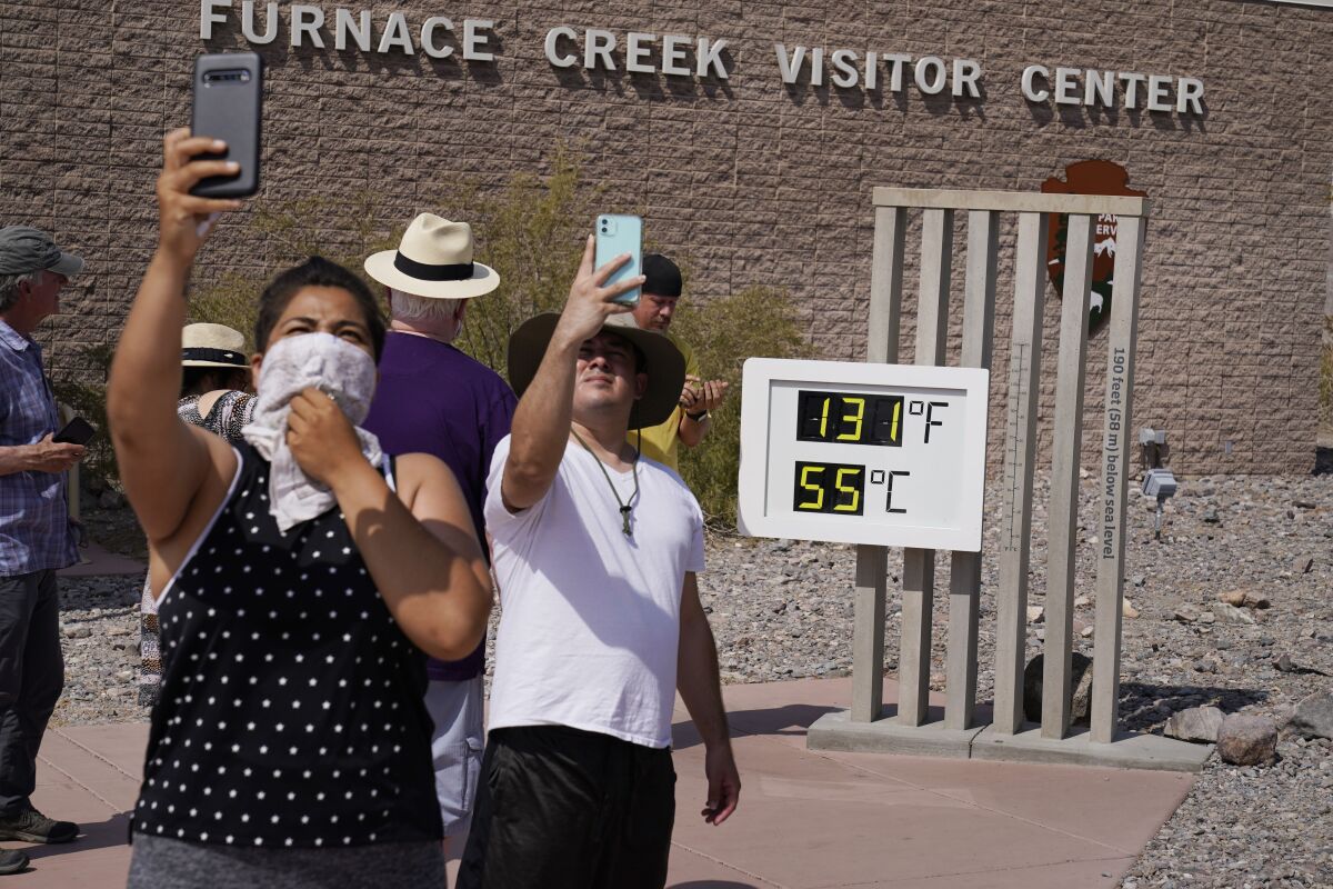 People take selfies at the Furnace Creek Visitor Center's thermometer in Death Valley National Park.