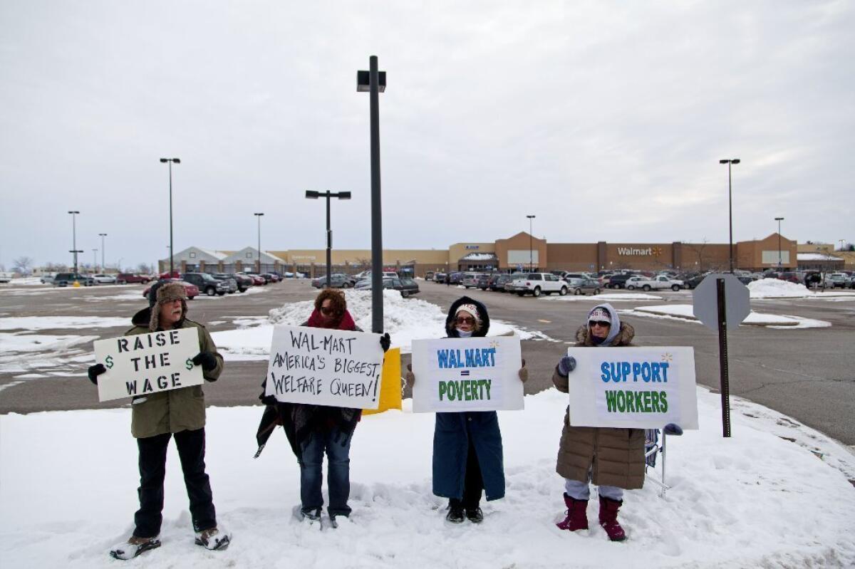 Protesters hold signs outside a Wal-Mart store in Watertown, Wis., on Friday.