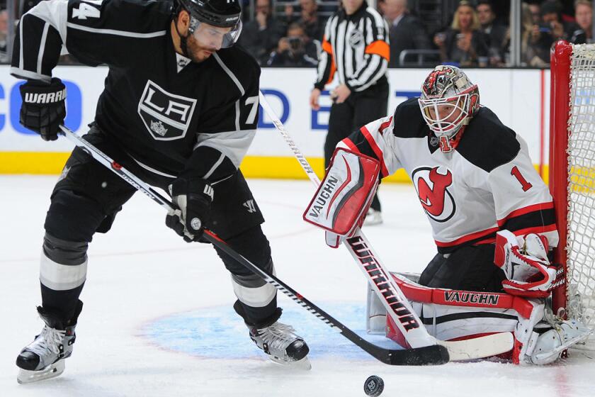 Kings forward Dwight King controls the puck in front of New Jersey Devils goalie Keith Kinkaid during the second period on Saturday.