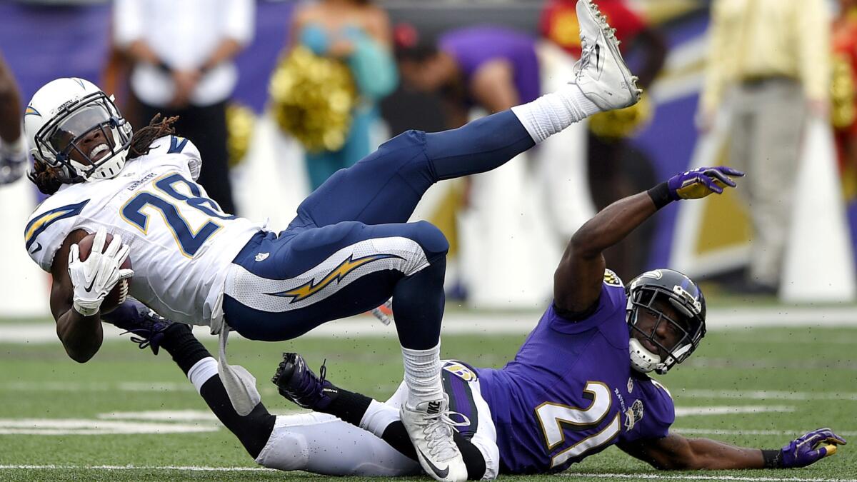 Chargers running back Melvin Gordon (28) is brought down by Ravens cornerback Lardarius Webb (21) in the second half Sunday.