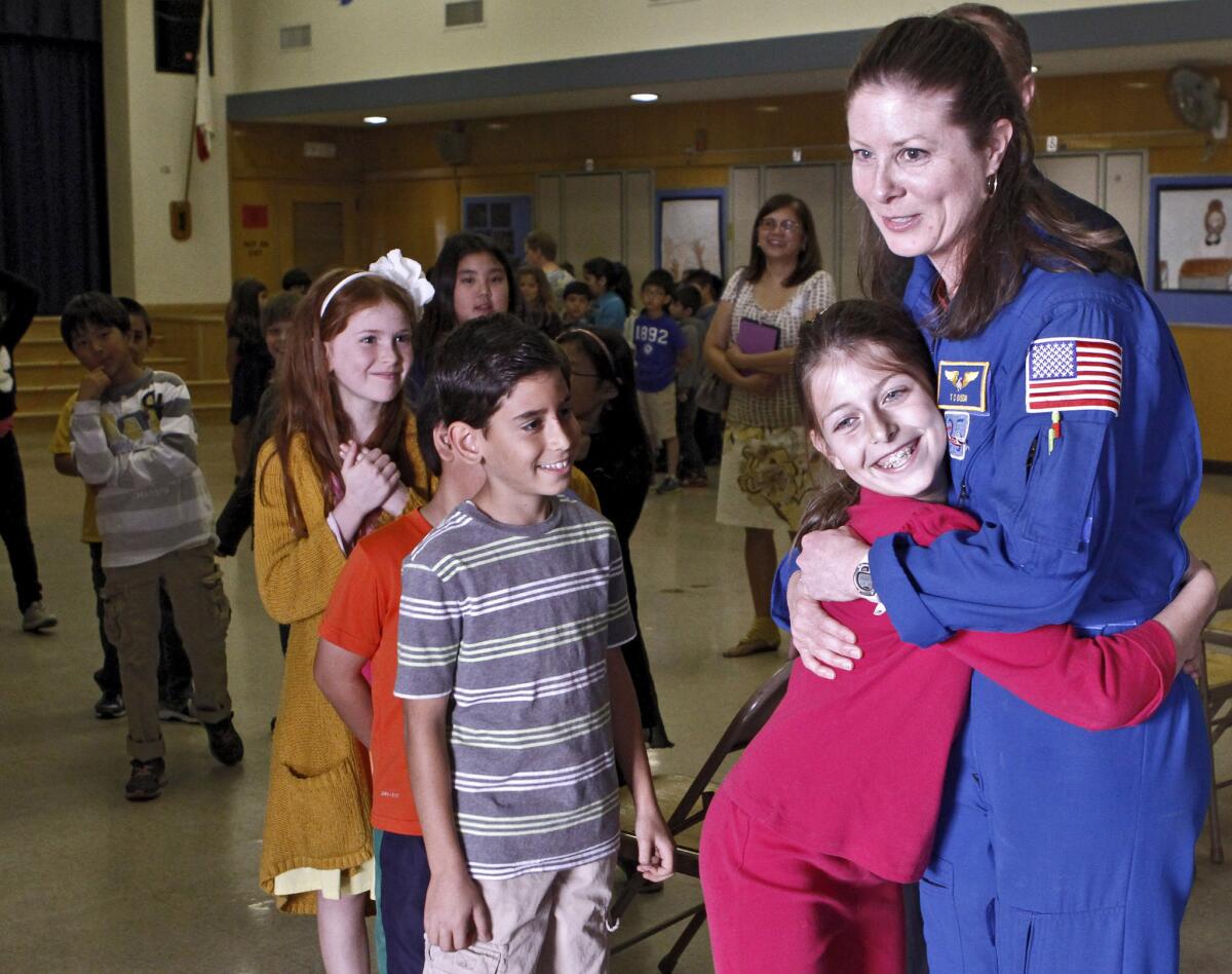 La Crescenta Elementary School students line up to give NASA astronaut Tracy Caldwell Dyson a hug after she gave a talk at the school about her career and time spent in space on Thursday, January 23, 2014.
