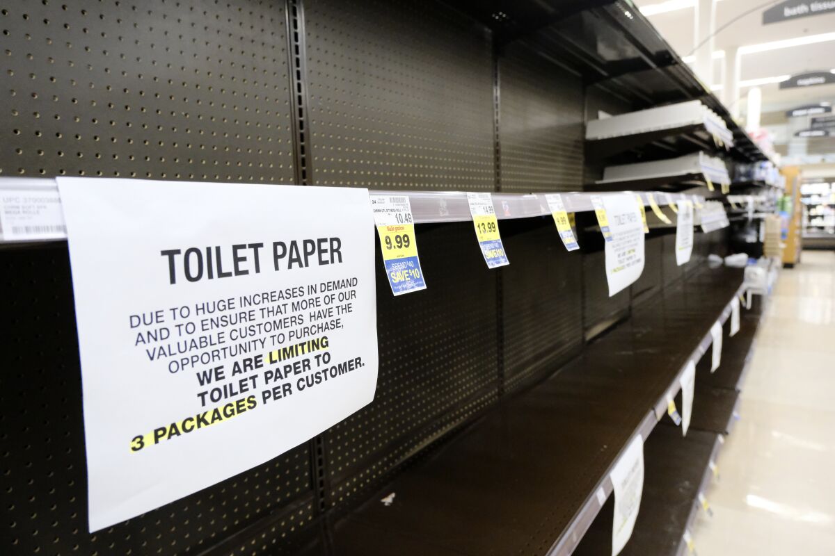 A notice limiting only 3 packages of toilet paper per customer is displayed on picked bare shelves after shoppers cleaned out the stock of paper and cleaning products at a local grocery store in Burbank, Calif. on Saturday, March 14, 2020. Californians wanting to escape the new reality of the coronavirus at the movies, casino or amusement park are running into the six foot rule. State health officials issued new guidance Saturday urging theaters to keep attendance under 250 people and ask strangers to sit six feet apart. (AP Photo/Richard Vogel)