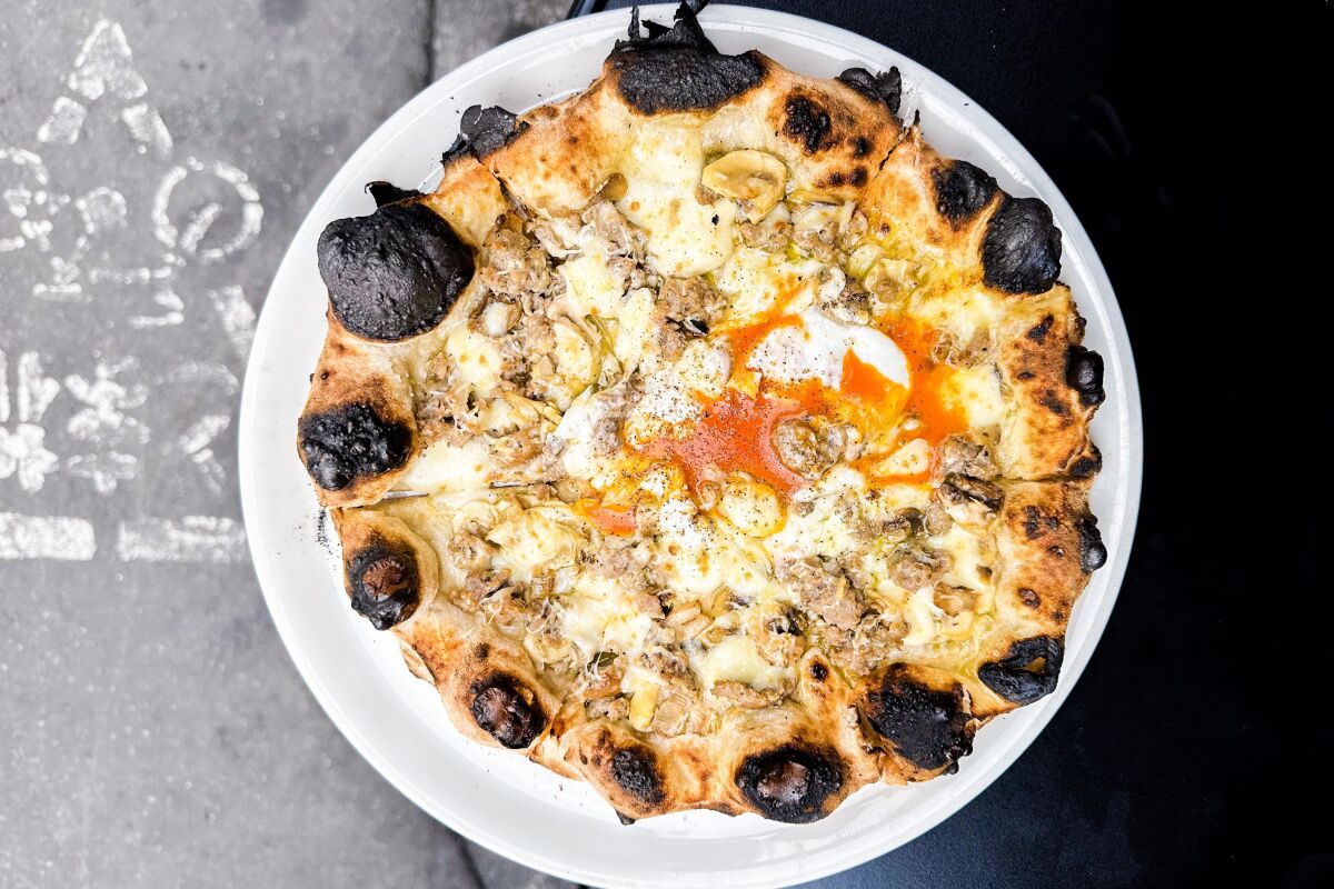 The Bismarck — topped with sausage, mushrooms and a signature runny yolk — at Pizza Studio Tamaki in Tokyo.