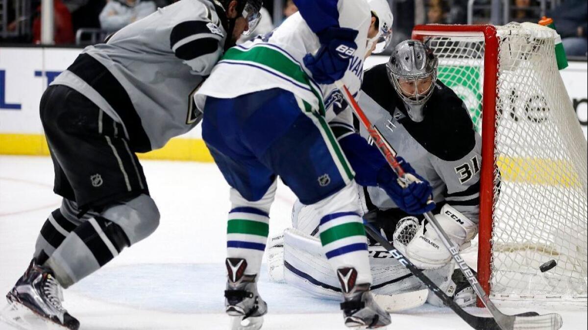 Kings goaltender Ben Bishop watches the puck go wide of the goal on a shot by Canucks center Henrik Sedin during the third period on Saturday.