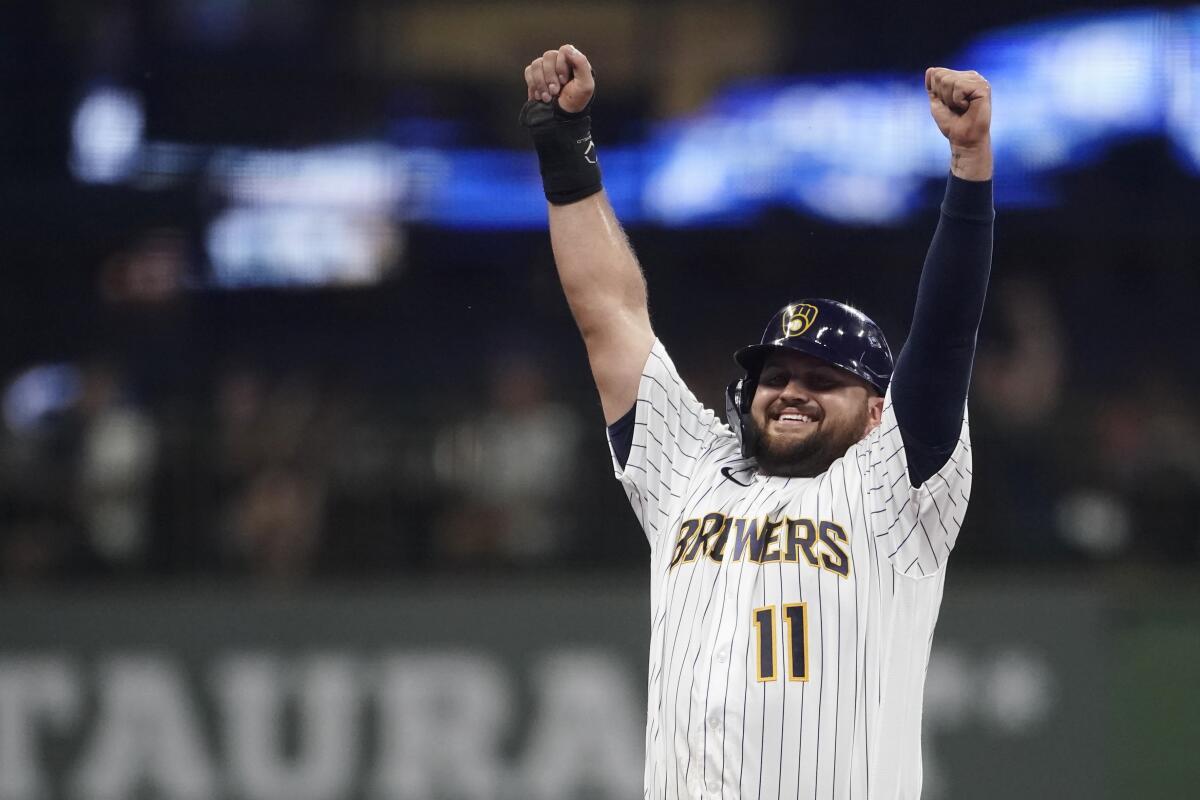 Milwaukee Brewers' Rowdy Tellez gestures to the dugout after stealing second base during the third inning of the team's baseball game against the Cincinnati Reds on Friday, Aug. 5, 2022, in Milwaukee. (AP Photo/Aaron Gash)