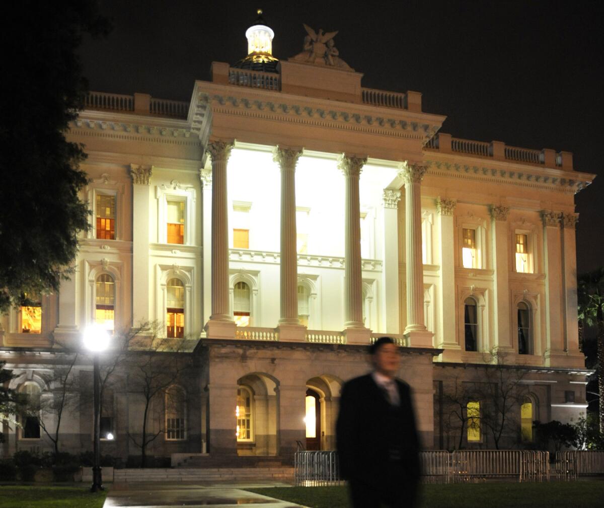 The state Capitol at night. A prominent lobbying firm in Sacramento faces fines for failing to report fundraising that benefited about 40 state legislators and other officials.