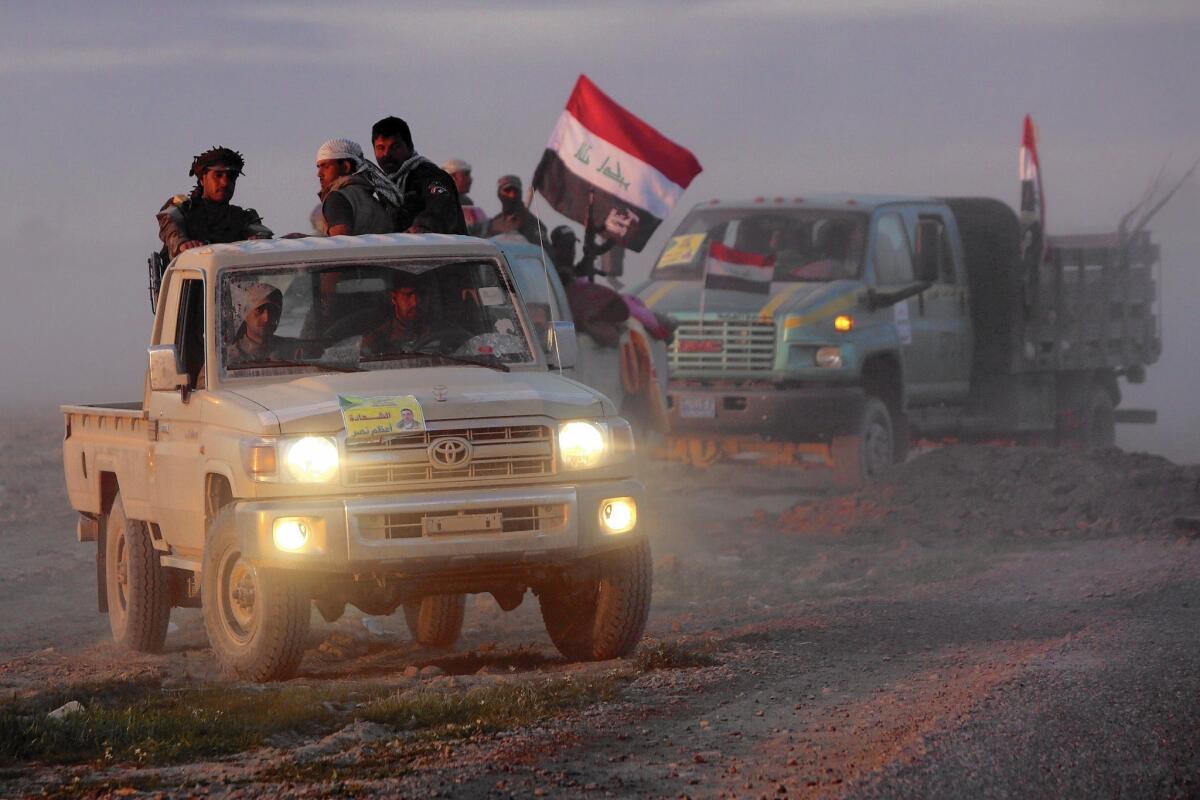 Iraqi fighters drive on the outskirts of Dawr on March 6, 2015, during a military operation to retake the Tikrit area from Islamic State.