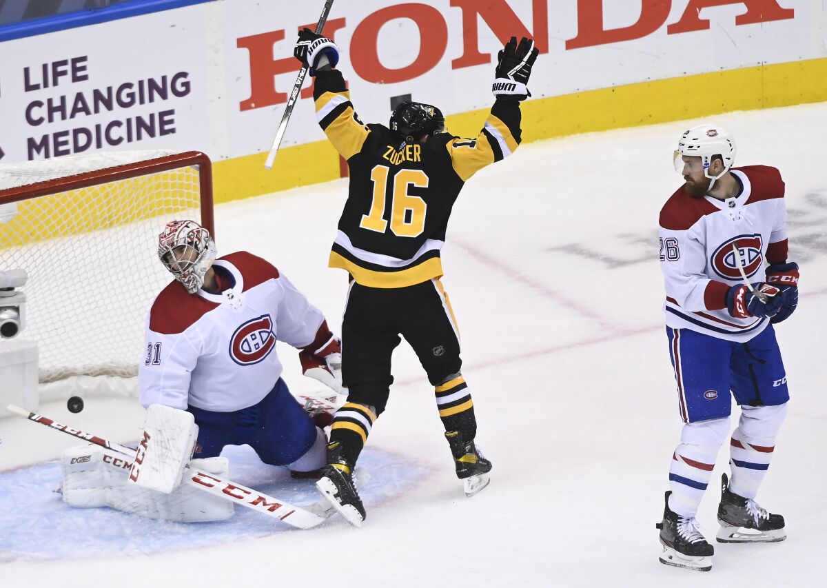 Pittsburgh Penguins left wing Jason Zucker (16) scores past Montreal Canadiens goaltender Carey Price (31) as Canadiens defenseman Jeff Petry (26) look on during the third period of an NHL hockey playoff game Monday, Aug. 3, 2020 in Toronto. (Nathan Denette/The Canadian Press via AP)