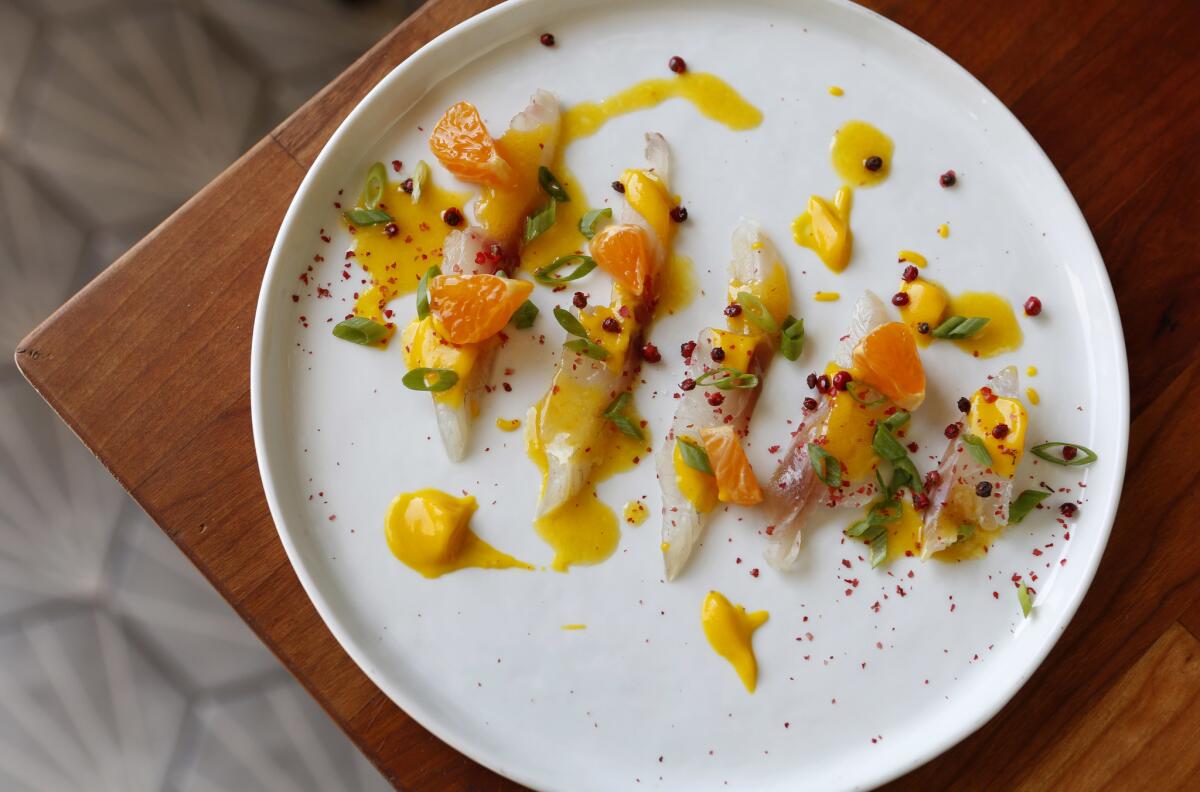 The orata crudo has slices of sea bream with crushed pink peppercorns and tangerine segments.