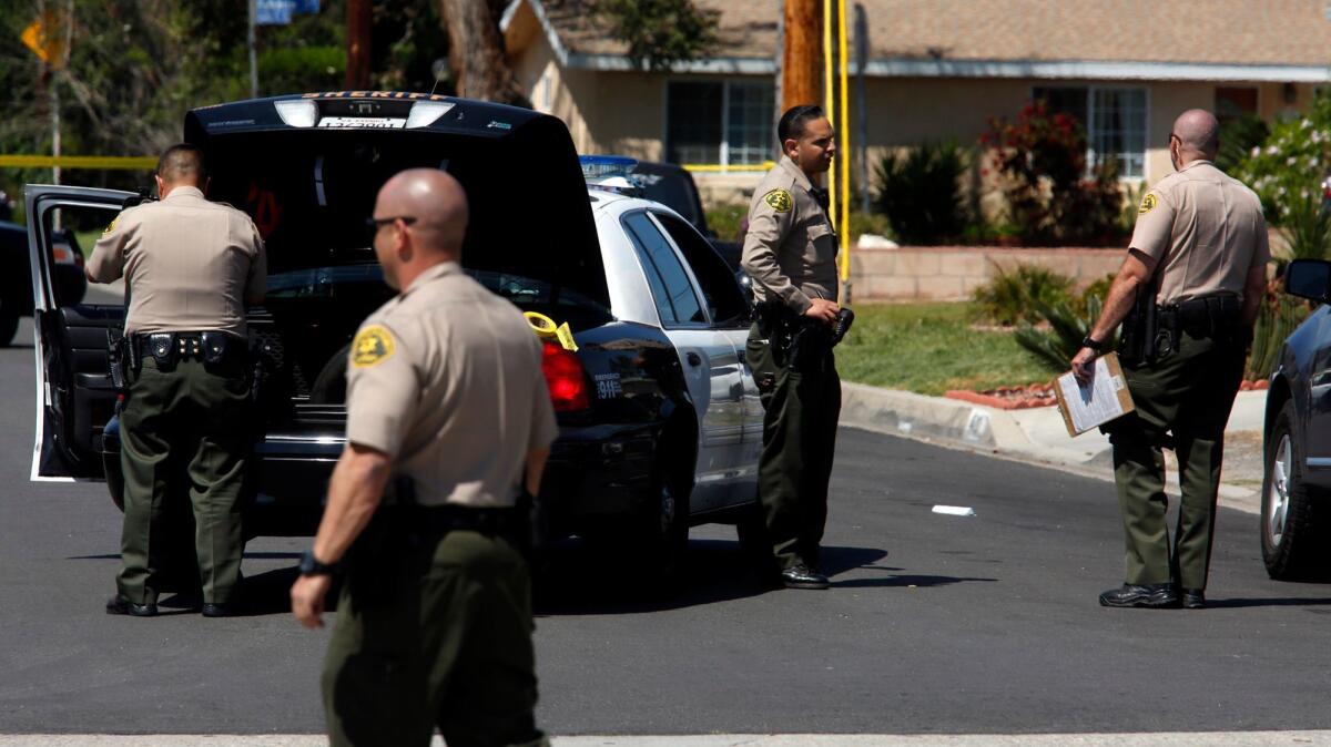 Los Angeles County sheriff's deputies investigate the scene where an armed suspect had been taken into custody in Covina on April 9, 2017.