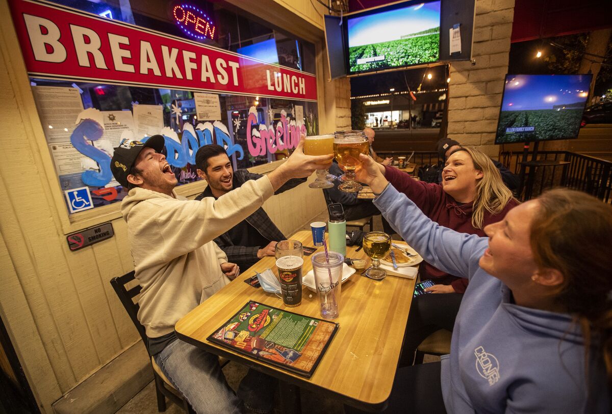 Friends toast at Cronies sports bar and grill in Agoura Hills.