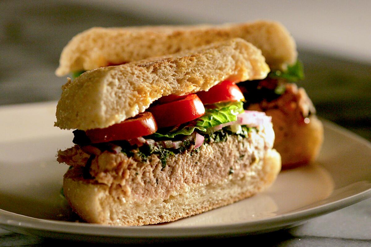 Two halves of Italian tuna and shiso sandwich side by side on a plate