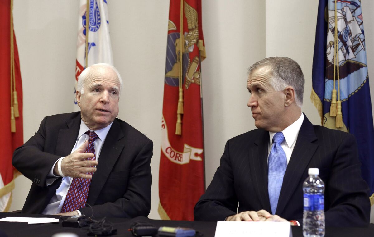 Sen. John McCain (R-Ariz.) and North Carolina Senate candidate Thom Tillis participate in a national security roundtable in Goldsboro, N.C., on Thursday. Tillis was one of the first Republicans to suggest banning travel to the United States from West African nations dealing with the Ebola outbreak.