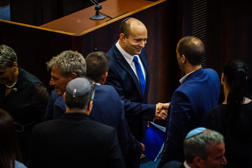 JERUSALEM, ISRAEL -- JUNE 13, 2021: Incoming Prime Minister Naftali Bennett greets lawmakers after he completes his address to the Knesset, Israel's parliament, and before lawmakers gather to cast their vote of confidence to confirm the new coalition government which unseated Benjamin Netanyahu as Prime Minister in Jerusalem, Israel, Sunday, June 13, 2021. (MARCUS YAM / LOS ANGELES TIMES)