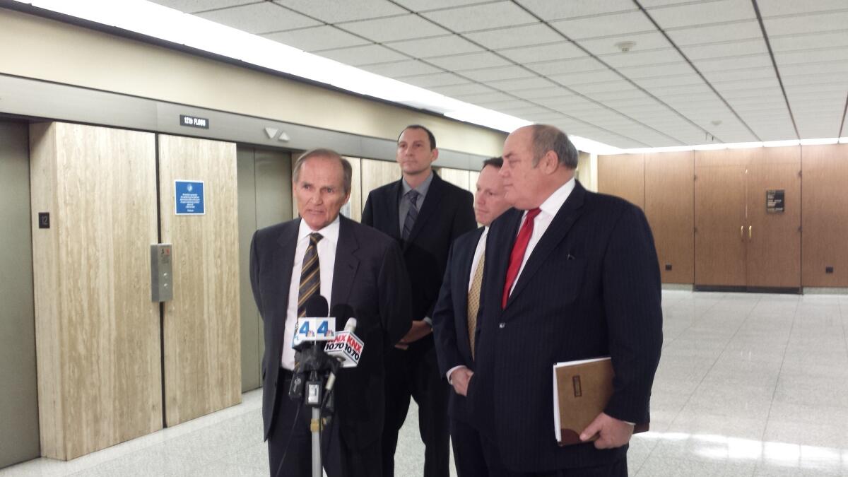 From left, attorneys Robert Sheahen, Daniel Perlman and Dan Melnick speak to reporters at Los Angeles County Superior Court on behalf of their client, Ken Tarr, in the background.