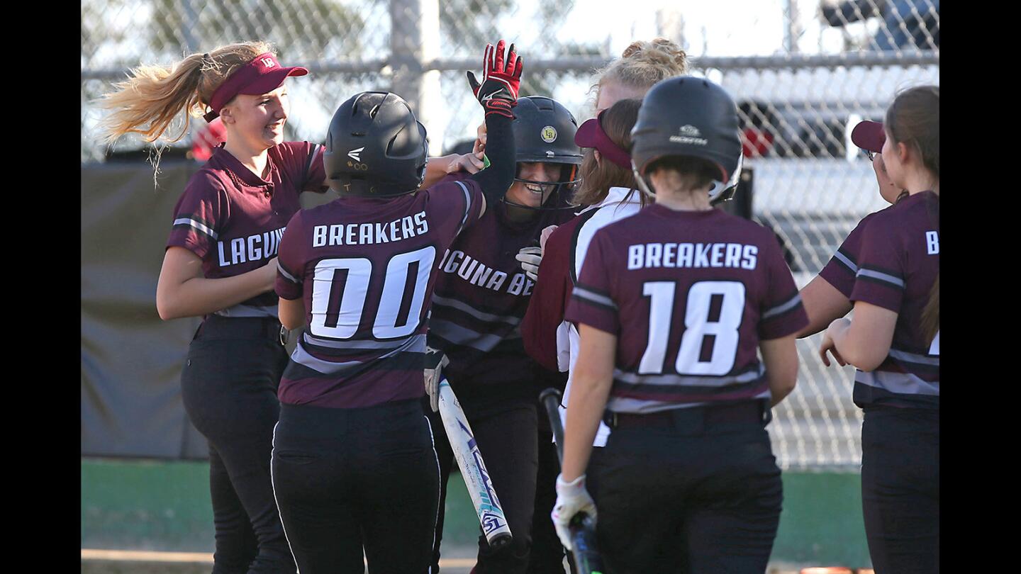 Laguna's Lola Fisher is congratulated by teammates after hitting an inside the park homer in girls varsity softball action against Brethren Christian on Wednesday.