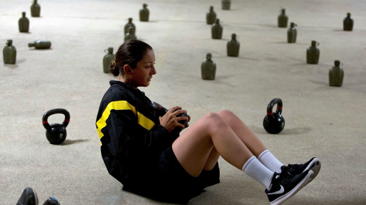 A female U.S. Army recruit exercises before dawn at Ft. Benning, Ga., on Oct. 4, 2017.