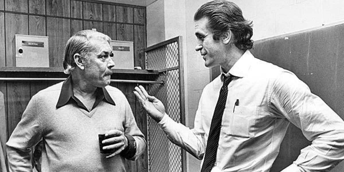 Lakers owner Jerry Buss talks with coach Pat Riley in Lakers locker room following a game.