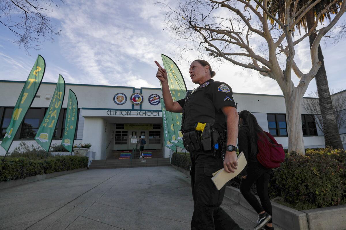 Police officer monitors traffic as students arrive Thursday at Clifton Middle School in Monrovia
