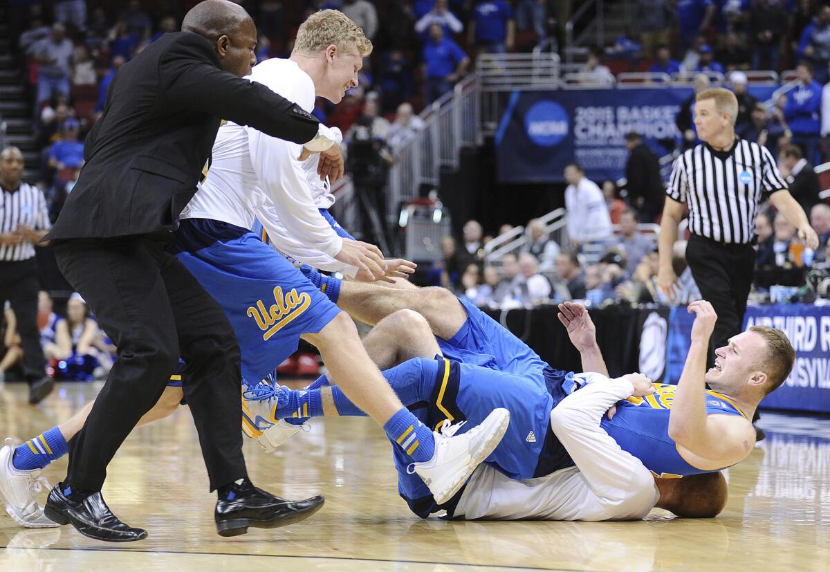 UCLA guard Bryce Alford is tackled to the court by teammate and brother Kory after the Bruins beat SMU on Thursday.