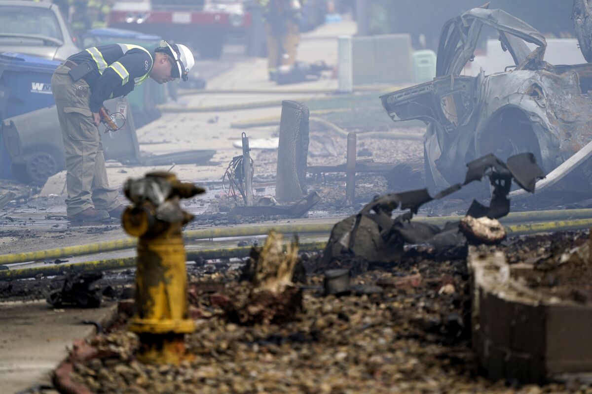 A fire official looks over the scene of a small plane crash.