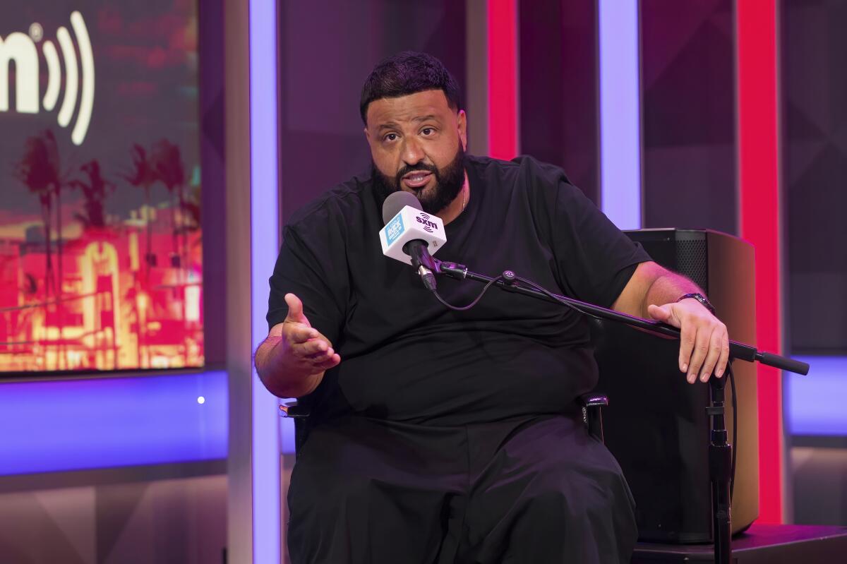 DJ Khaled sits and speaks into a microphone while being interviewed on Sirius XM 