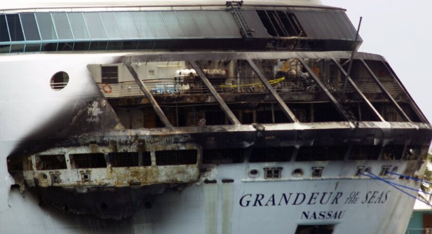 The fire-damaged exterior of Royal Caribbean's Grandeur of the Seas cruise ship is visible in Freeport, Grand Bahama island. Royal Caribbean said the fire occurred early Monday on the mooring area of Deck 3 while the ship was en route from Baltimore to the Bahamas. It was quickly extinguished, but the cruise was cut short.