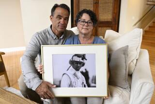 FILE - Derek and Suzi Alkonis pose with a photo of their son Lt. Ridge Alkonis on Wednesday, June 1, 2022, in Dana Point, Calif. (AP Photo/Denis Poroy, File)