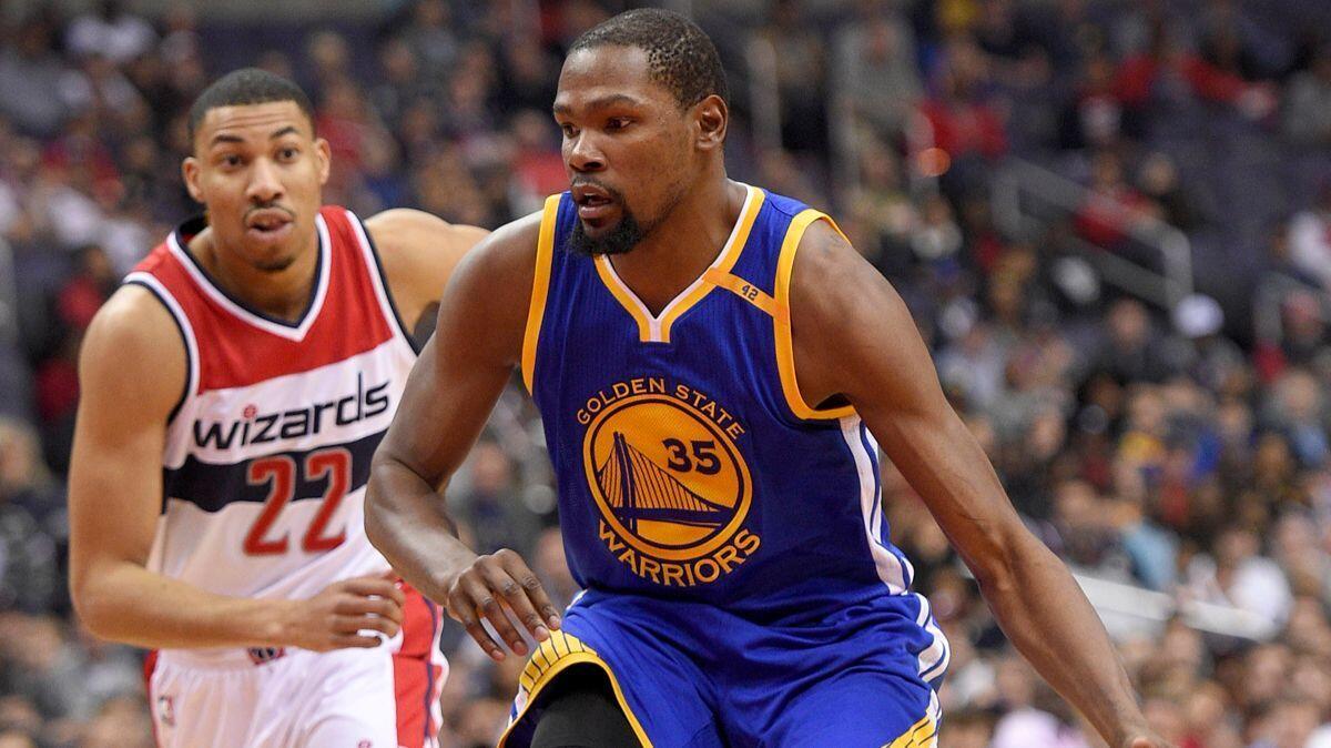 Golden State Warriors forward Kevin Durant (35) dribbles the ball past Washington Wizards forward Otto Porter Jr. (22) during the first half Tuesday.
