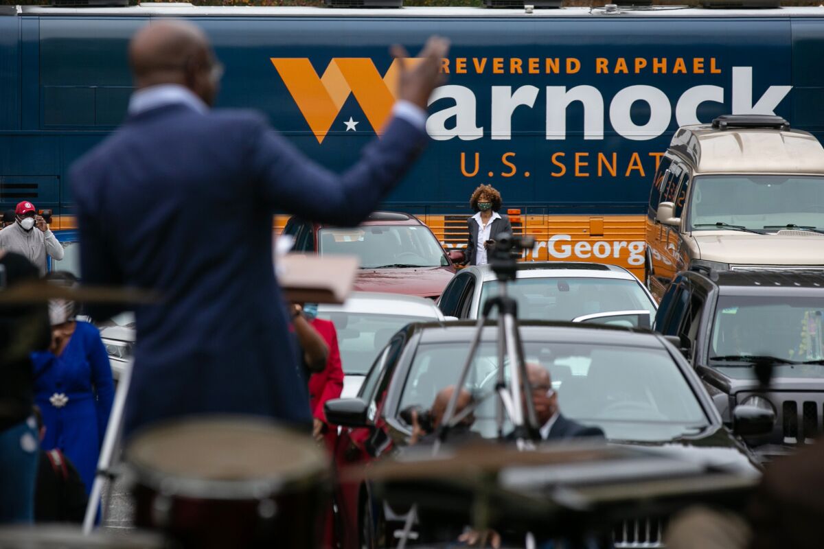 The Rev. Raphael Warnock speaks to churchgoers in and out of their cars at a recent socially distanced drive-in service.