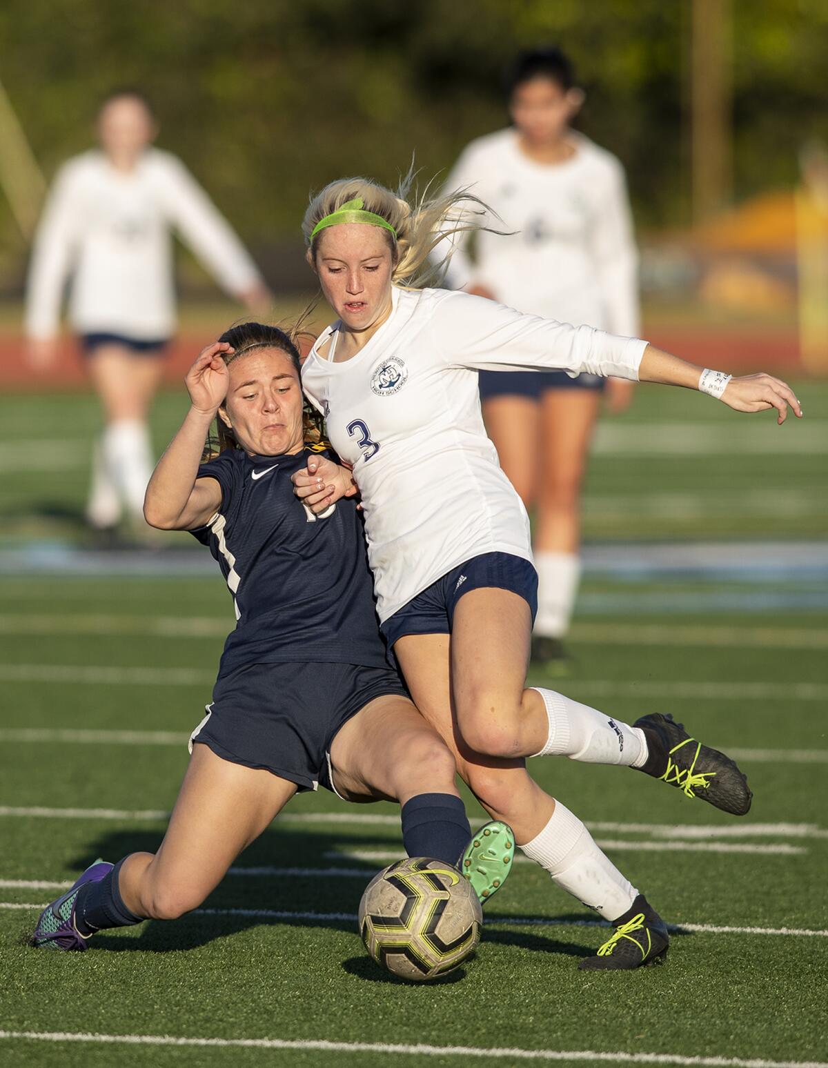 Marina's Eve Frousiakis, left, battles for a ball against Newport Harbor's Reese Bodas in a Wave League match on Tuesday.