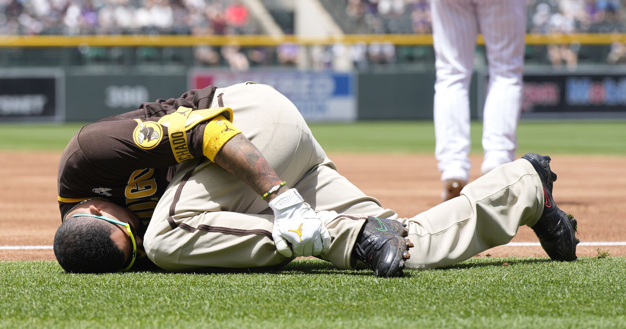 San Diego Padres third baseman Manny Machado grabs his left ankle 