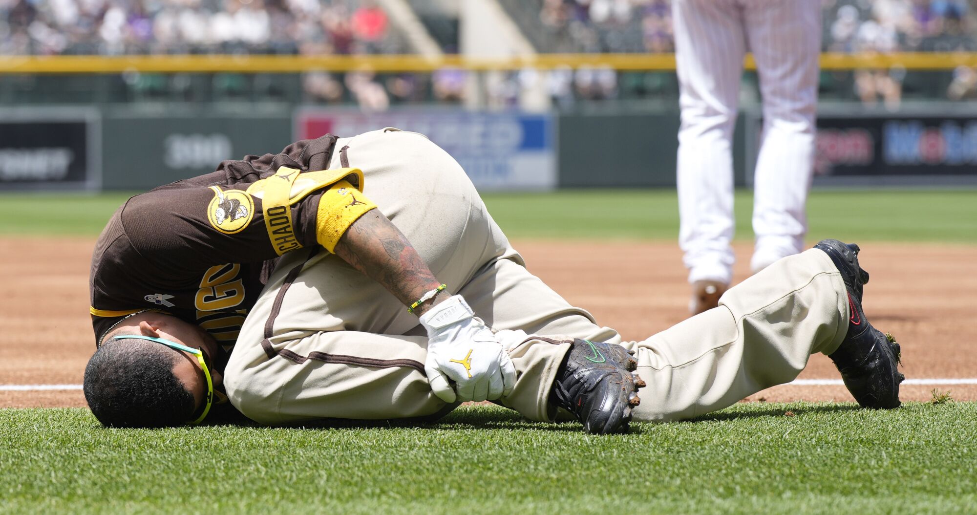 San Diego Padres third baseman Manny Machado grabs his left ankle