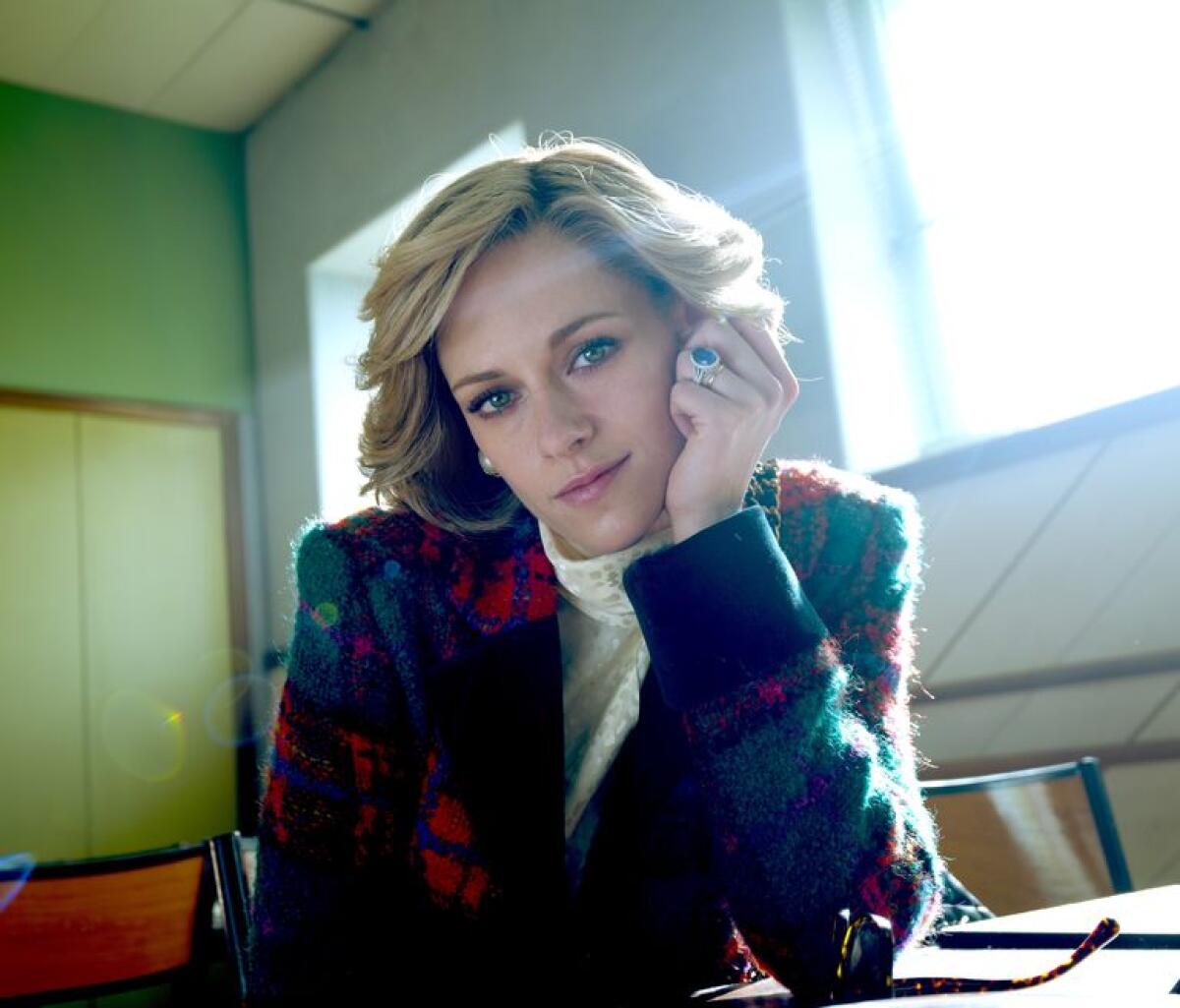 A young woman seated at a table bathed in sunlight in the movie "Spencer."