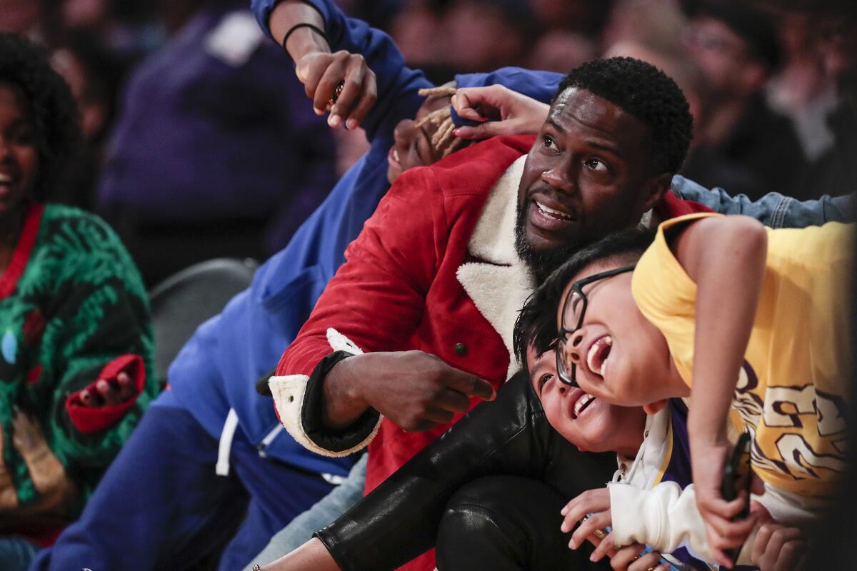 Comedian Kevin Hart and other Lakers fans mug for television cameras as they sit courtside for the Lakers-Clippers game on Dec. 25, 2019, at Staples Center.