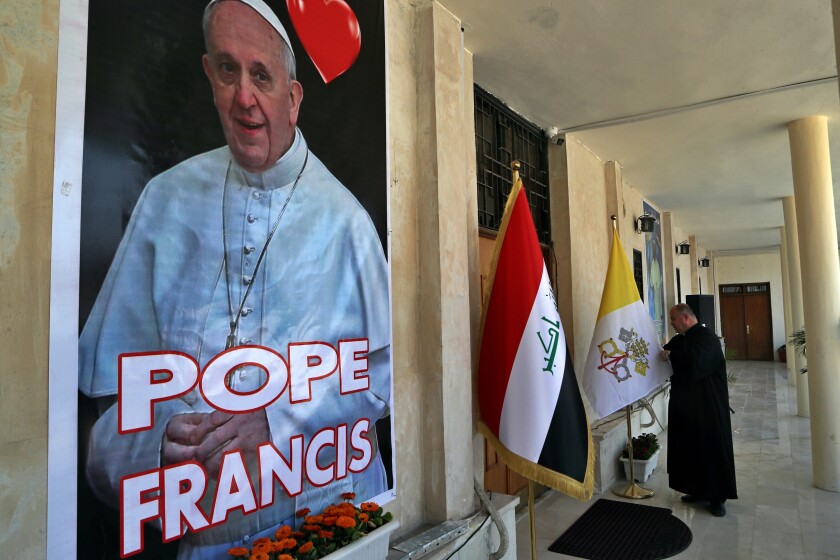 Father Nazeer Dako arranges a Vatican flag to welcome Pope Francis at St. Joseph's Chaldean Church ahead of the Pope's visit, in Baghdad, Iraq, Tuesday, March 2, 2021. (AP/Photo/Khalid Mohammed)